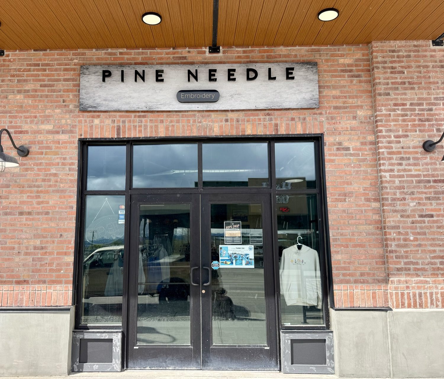 Pine Needle Embroidery storefront with brick facade and signage in Driggs, Idaho